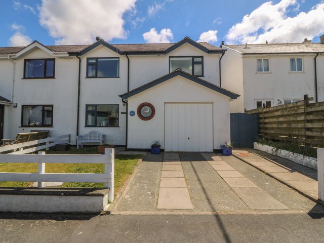 A house with a garage and driveway at Wingelock in Rhosneigr