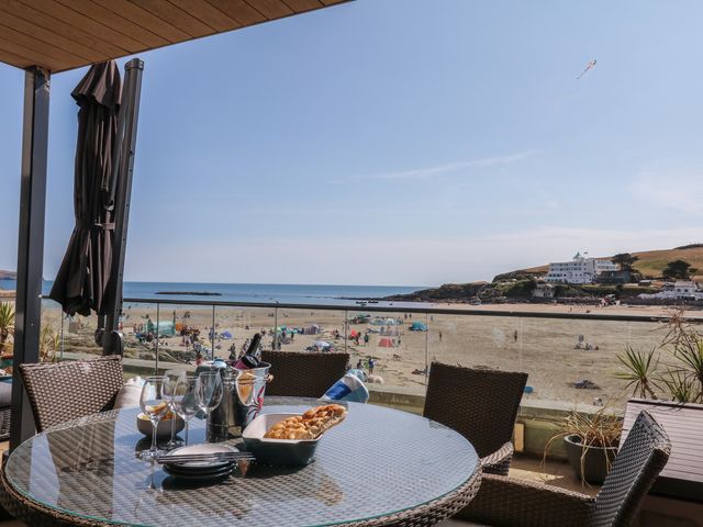 An outdoor dining area with a table and view of the beach at 4 Burgh Island Causeway in Bigbury