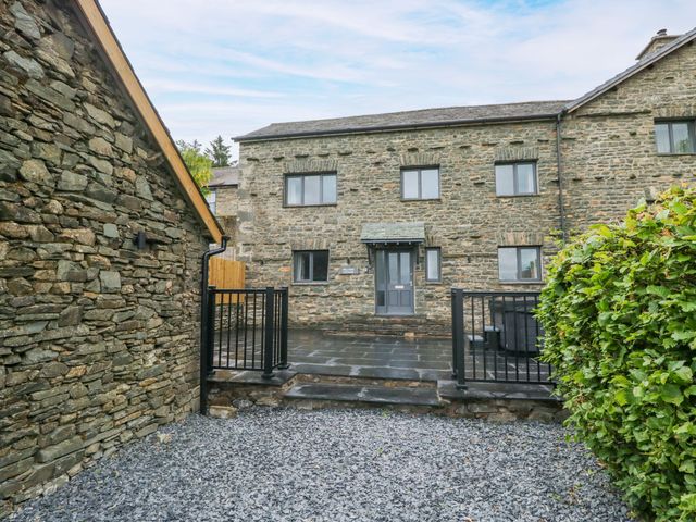 An exterior view of a house with stone walls and a fenced entrance at Fell View Cottage Lambrigg near Kendal