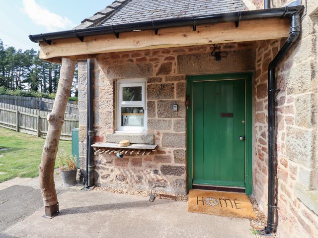 An entrance with a green door and welcome mat at Bruno's Bothy Middleton near Belford
