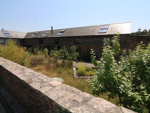 An outdoor area with a building and garden at The Milking Shed in Bantham
