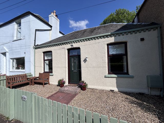An outdoor view of a house with a front door and bench at 60E Wellgate in Lanark