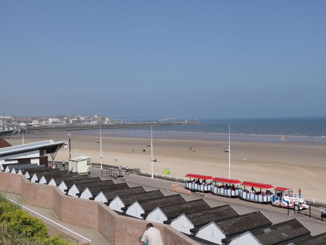 A beach with beach huts and a view of the sea at Apt 8 @ Hunter's Quay Bridlington
