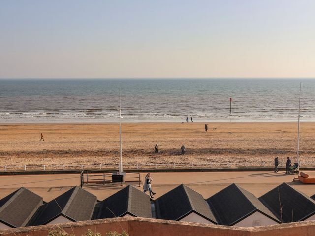 A beach scene with people walking near the sea at Apt 9 @ Hunter's Quay, Bridlington