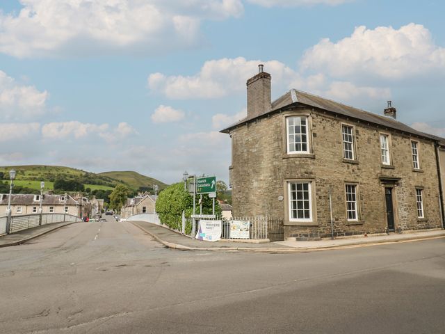 A street view with a building and road signage at Eskvale House in Langholm