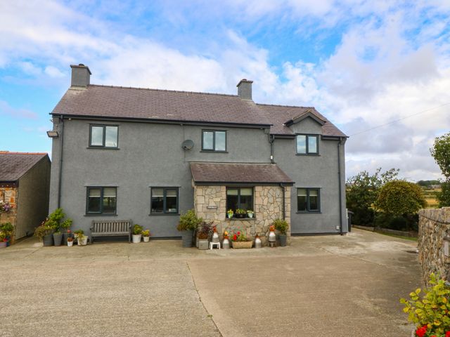 A house with a stone front and plants at Tyn Rallt Newborough