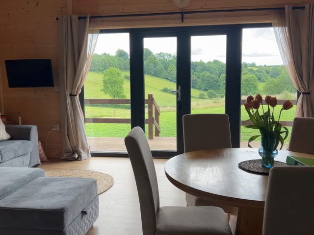 A living room with a sofa and table looking out to the fields at Primrose Higher Wambrook near Chard
