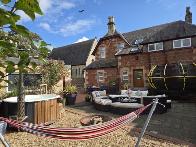 A garden with a hammock and jacuzzi at The Old Rectory in Largs