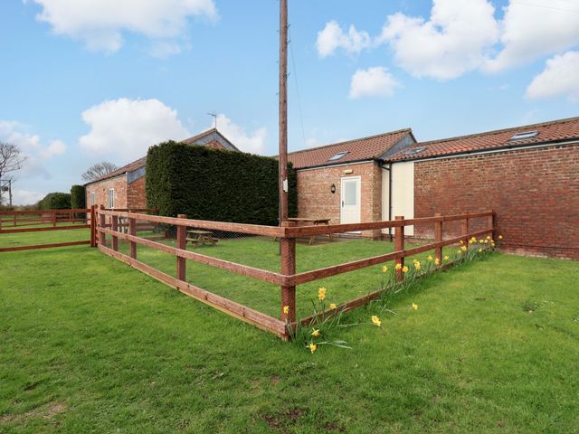 An outdoor area with a fenced space, table and chairs at Puffin in Flamborough