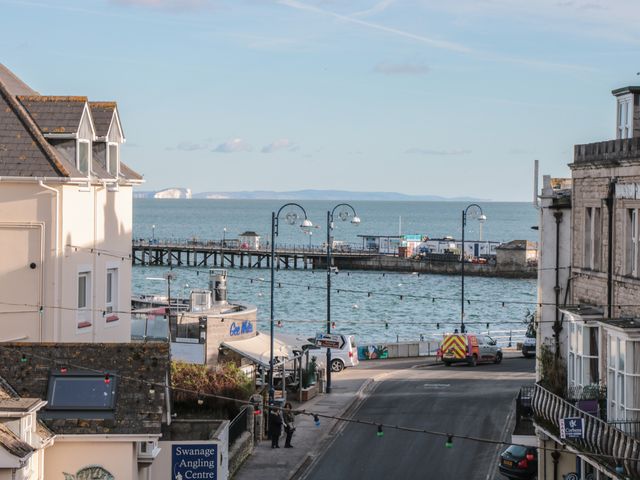 A street with buildings on either side leading to a pier extending into the sea at Purbeck Hotel Apartments - Flat 5 in Swanage
