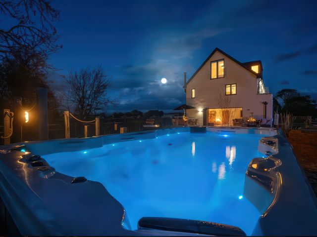 A swimming pool with a house in the background at Station House Highbridge