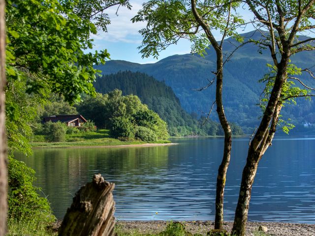 A scenic view of a lake with mountains and trees at Strathyre Golden Oak Lochside Strathyre, Ben Ledi