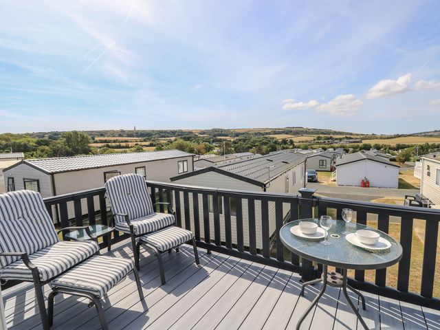 An outdoor deck with chairs and table at 31 Crosswinds in Bembridge