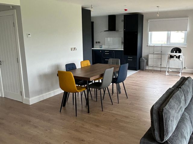 A dining area with a table and chairs adjacent to a kitchen at 30 River Run in Belturbet