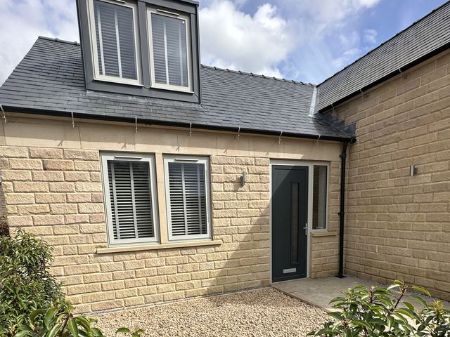 An exterior view of a house with a door and windows at Oakwood Lodge Tansley