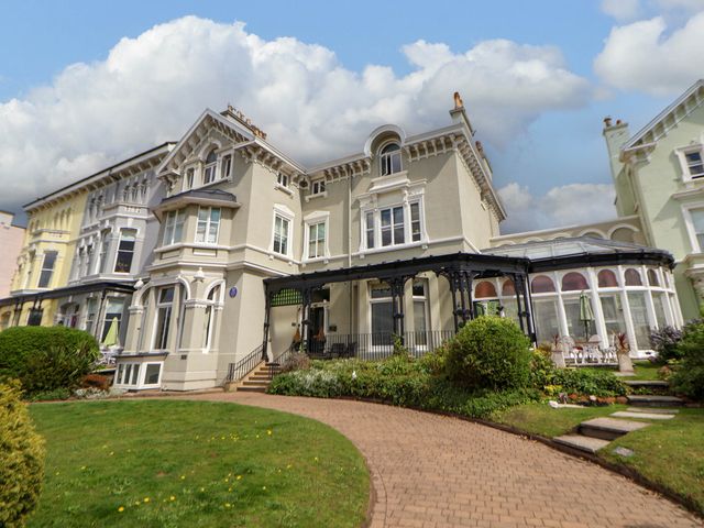 An exterior view of a large detached house with a brick pathway and garden at Ismay Lounge Apartment- Titanic Interest in Waterloo Merseyside