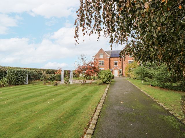 An outdoor area with a house and garden at The House at School Farm in Hassall near Haslington