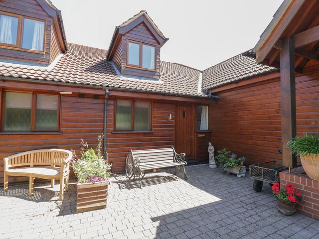 An outdoor area with a bench and flower planters at Heron Cottage