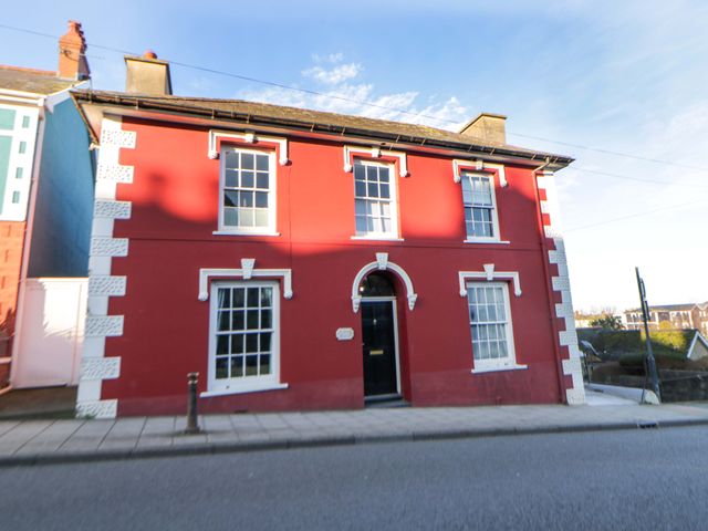 A red house with white features on a street at Island House Aberaeron