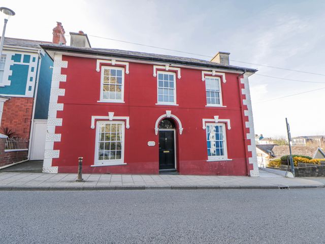 A red house with white trim and large windows at Island House Aberaeron