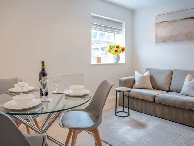 A dining room with a table and couch at Ullswater in Ulverston