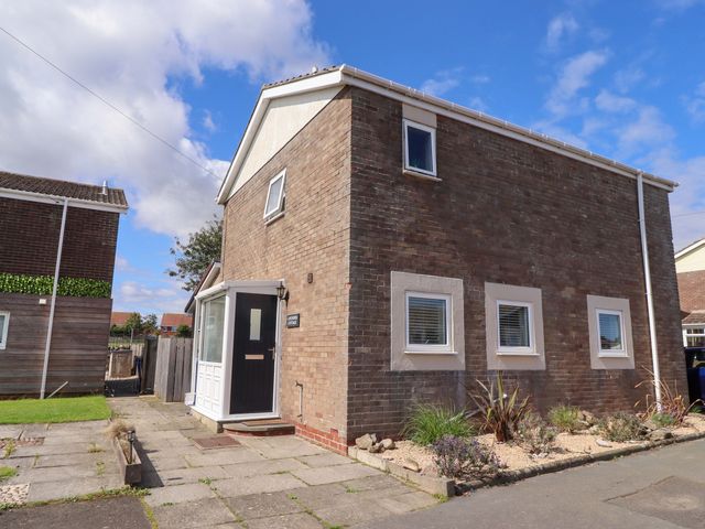 A house with a front door and windows at Lavender Cottage Beadnell