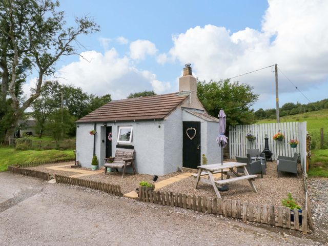 A cottage with a bench and table outside at High Wreah Bolt Hole in Cleator Moor