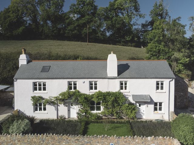 An exterior view of a house with a garden at Lower Well Farm House in Totnes