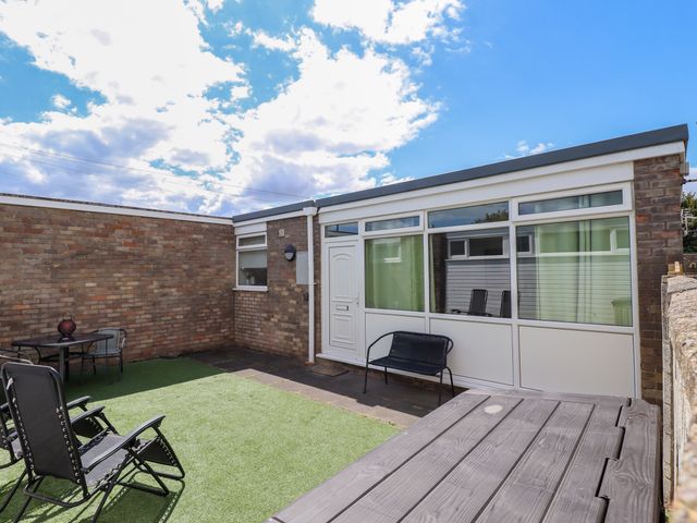 A garden with a table and chairs at Seaside Retreat Chapel Point near Chapel St Leonards