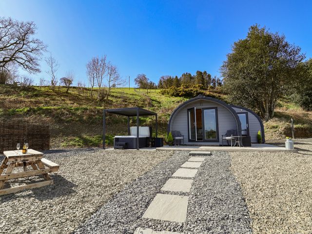 An outdoor area with a cabin, hot tub, and picnic table at Lili Wen Fach Ruthin