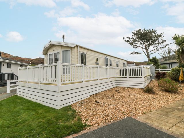 A mobile home with a deck and gravel area at Seaviews in Nefyn