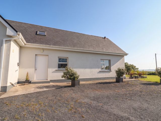 An exterior view of a house with planters at The Boathouse in Carrigaholt, County Clare