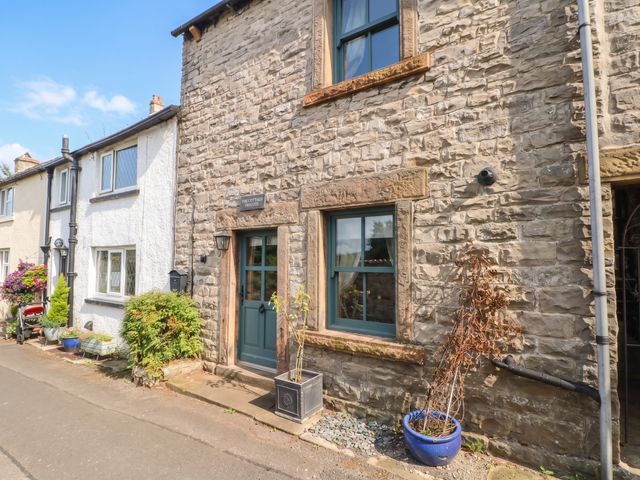 A stone wall with a front door and window at The Cottage O'ergate in Bradwell