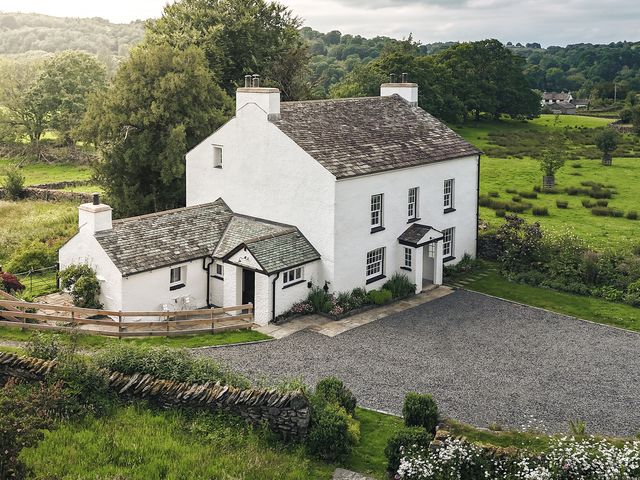 A house with a driveway and garden at Green Yew in Winster near Bowness-On-Windermere