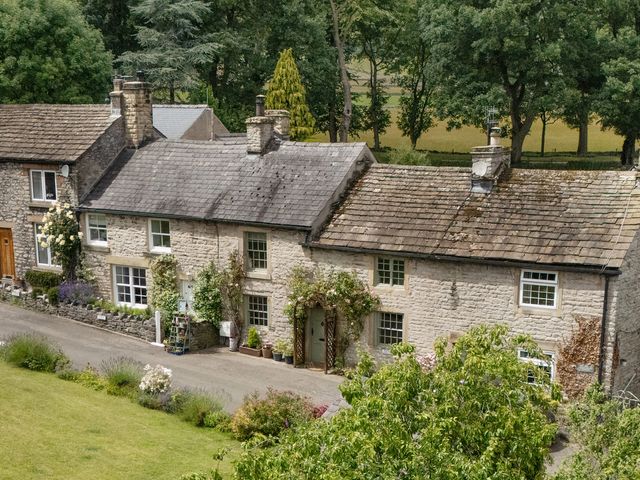 A row of stone houses with gardens at Buttercup Cottage in Castleton, Peak District