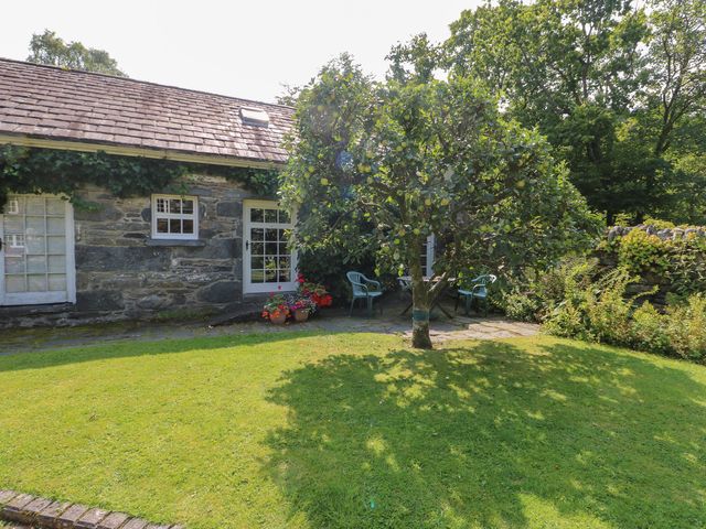 An outdoor area with a tree and chairs at Royal Oak Farm Cottage Betws-y-Coed