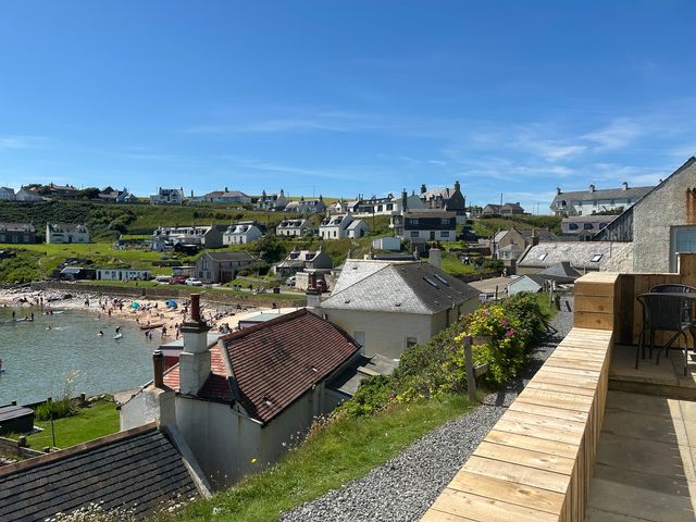 A view of houses and a beach with people at The Breakers in Newburgh, Aberdeenshire