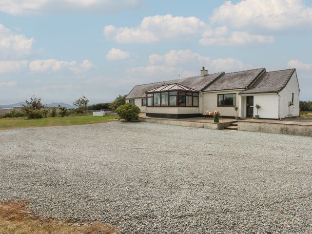 A house with a gravel area and plants at Tir Mawr in Llanfairpwllgwyngyll