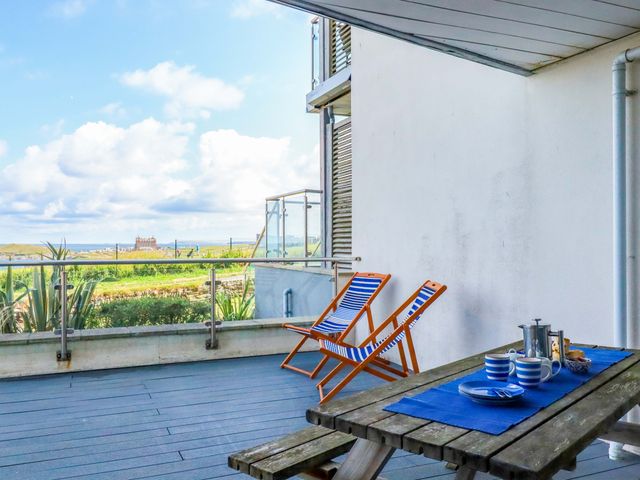 A balcony with chairs and a table at 4 Ocean Gate in Newquay