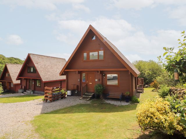 A cabin with a front door and garden at Thistle Dubh ('Doo') in Sandyhills