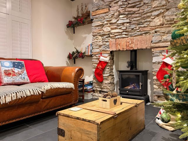 A living room with a sofa and fireplace at The Nook in Brixham