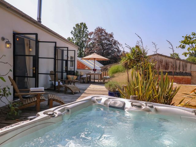 An outdoor area with a hot tub and seating at Burrows in Venn Ottery near Sidmouth