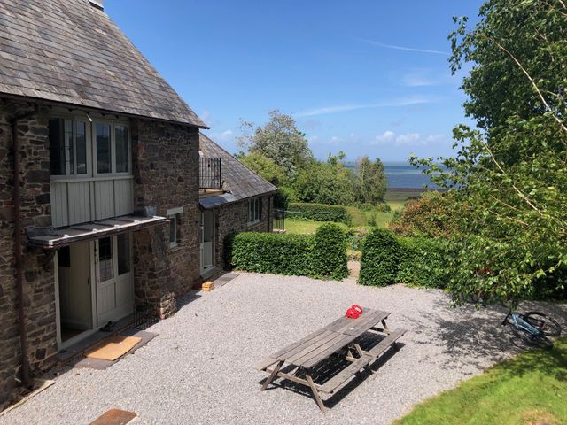 An outdoor area with a picnic table and trees at Worthy Barn Porlock Weir