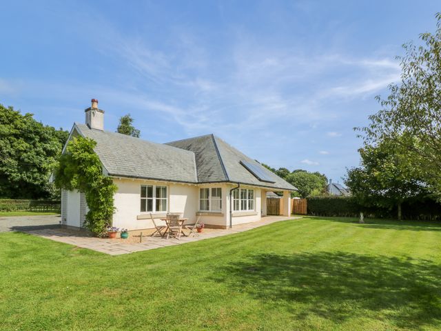 A single-story house with a tiled roof and solar panel surrounded by a grass lawn at Runglee in Duns