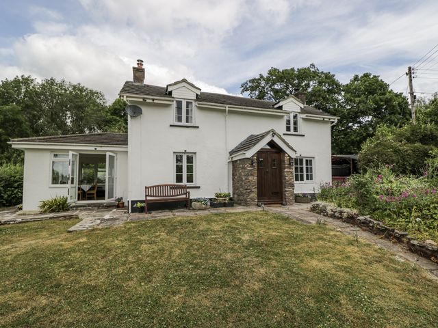 A house with a garden and patio at Woods Cottage Kingcoed near Raglan