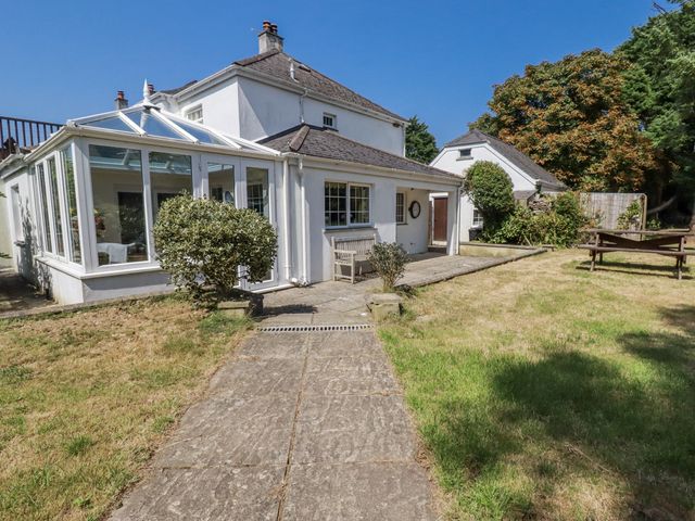 A house with a conservatory and garden area at Temple House Goonhavern