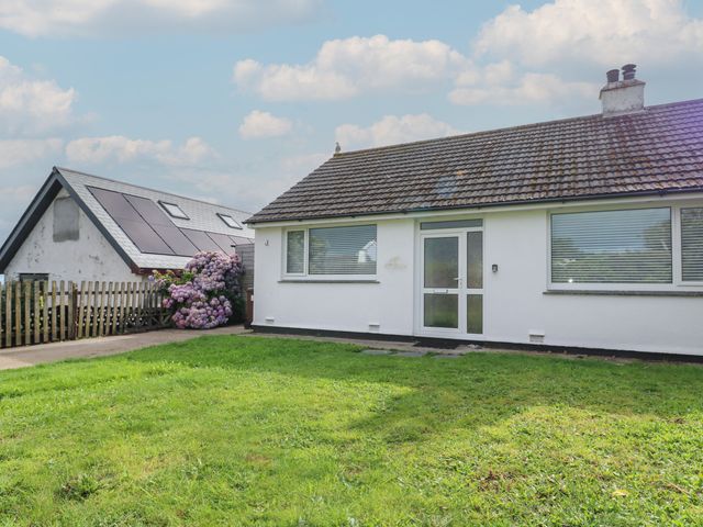 A white house with a tiled roof and green lawn in front at Bod A Quinte in Carbis Bay