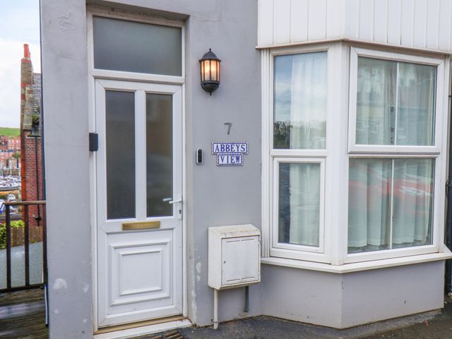 Front door and window of a building with a sign reading Abbeys View in Whitby