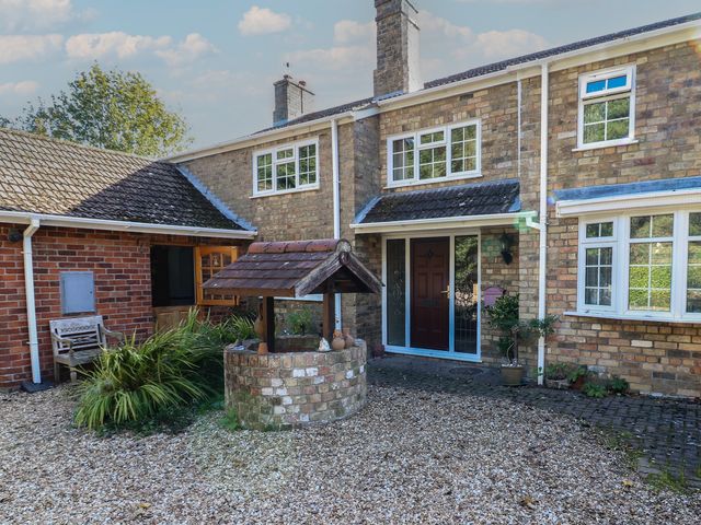 A house with a well and plants at Larkspur Cottage in Alford