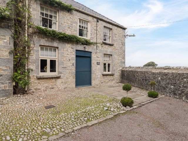 An outdoor area with a stone wall and door at The Stables at Gileston Manor St Athan